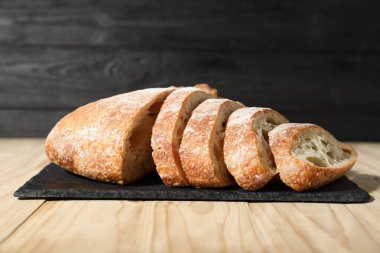 Hafif ahşap masada taze kesilmiş ekmek, yakın plan.