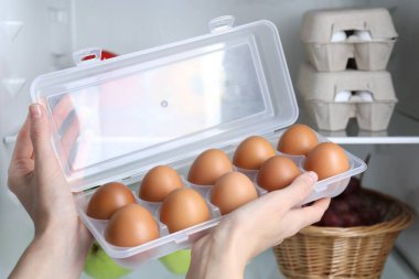 Dolapta çiğ tavuk yumurtası taşıyan kadın, yakın plan.