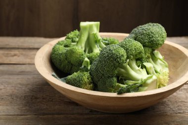 Tahta masadaki kasede taze çiğ brokoli, yakın plan.