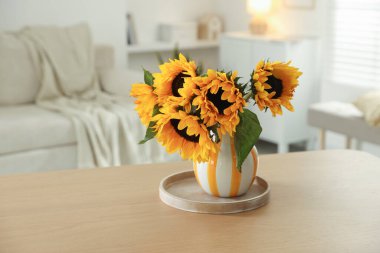 İçerideki ahşap masada vazoda güzel ayçiçekleri, metin için yer