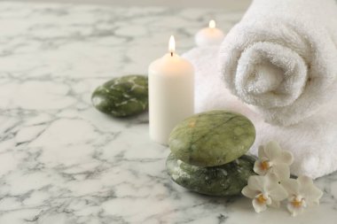 Güzel bir spa kompozisyonu, beyaz mermer masada yanan mumlar, yakın plan. Metin için boşluk