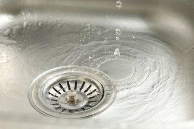 Water going down sink drain, closeup view