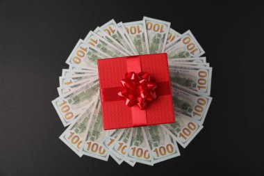 Hediye kutusu ve dolar banknotları siyah arkaplan, üst görünüm