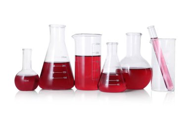 Different laboratory glassware with red liquid isolated on white