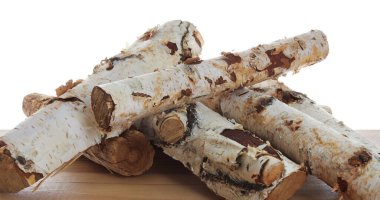 Ahşap masa üzerine kesilmiş odun yığını beyaz arka plana karşı