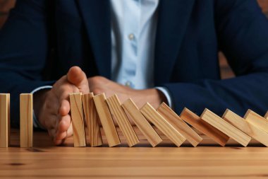 Risk. Tahta masada domino efektini durduran adam, yakın plan.