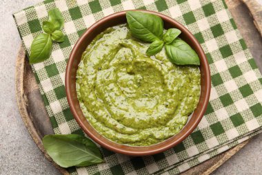 Fesleğen yapraklı taze pesto sosu gri masada, üst tarafta.