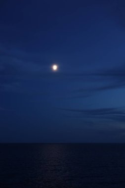 Gece gökyüzünde parlayan ay güzel denizin üzerinde