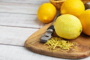 Limon lezzeti, taze meyve ve zester aleti açık ahşap masada, yakın plan.