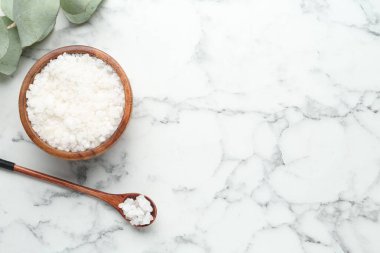 Deniz tuzu kasede, kaşıkta ve okaliptüs dalında beyaz mermer masada, düz yerde. Metin için boşluk