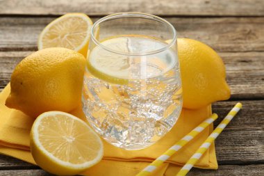 Limonlu, buzlu ve ahşap masadaki meyveli taze su, yakın plan.