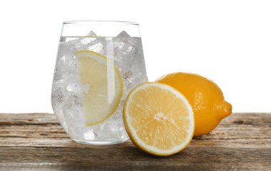 Tahta masadaki limonlu suyu beyaz arkaplana karşı ferahlatıyor