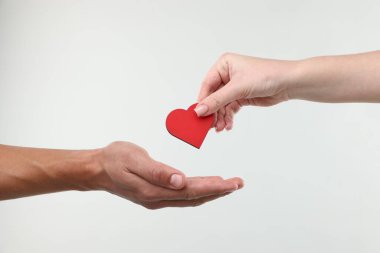 Kan bağışı. Kadın adama arka planda kalp figürü veriyor, yakın plan.