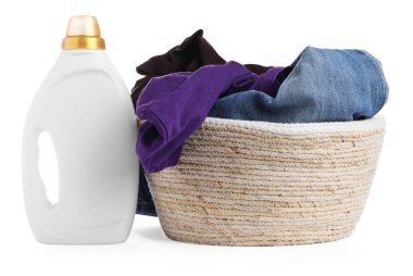 Çamaşır deterjanıyla dolu bir şişe ve beyaza izole edilmiş giysilerle dolu bir sepet.