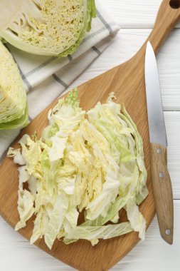 Taze kesilmiş Savoy lahanası ve bıçağı beyaz masada, düz yatıyordu.