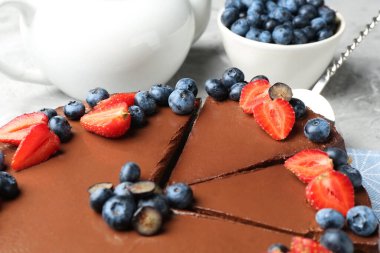 Açık gri masada böğürtlenli çikolatalı kek, yakın plan.