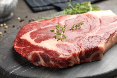 Gri masadaki çiğ et ve baharatlar, yakın plan.