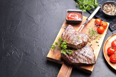 Bitkilerle, biberlerle, domateslerle, oyma çatalla ve ketçapla kaplı nefis ızgara biftekler. Metin için boşluk