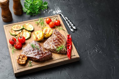 Koyu dokulu masada sebzeli ve şifalı ızgara biftekler. Metin için boşluk