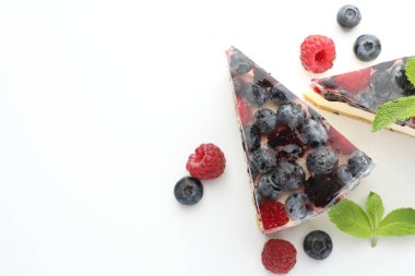 Böğürtlen ve nane şekerli leziz cheesecake parçaları beyaz masada, düz yatıyordu. Metin için boşluk