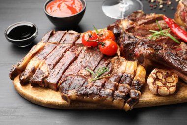 Biberiyeli ızgara biftek ve siyah ahşap masada sebze, yakın plan.