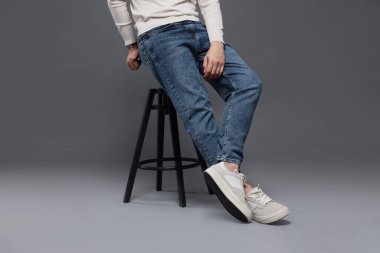 Gri arka planda kotlu şık bir adam, yakın plan.