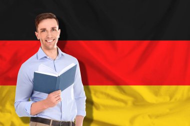 Almanya bayrağına karşı kitabı olan öğrenci ya da öğretmen. Dil okulu