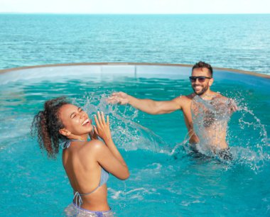Çift okyanus manzaralı havuzda eğleniyor.