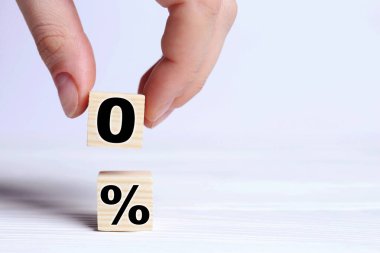 Komisyon yok. 0 'lı küpü başka bir masaya koyan kadın yüzde işaretli, yakın plan.