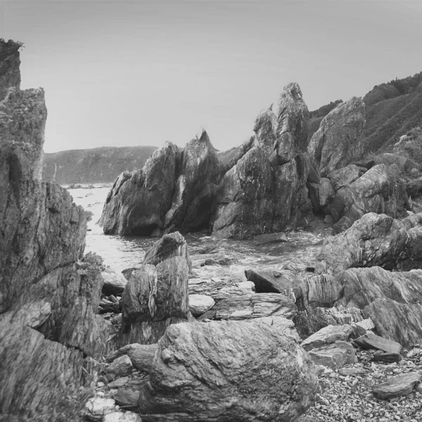 Landscape with sea and rocks. Sea coast with waves. The beauty of the wild. Dramatic style. Black and white photo