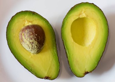Green ripe avocado fruit. Sliced half with pulp. Two halves. Healthy diet food. Culinary ingredient. Cooking food. Photo closeup