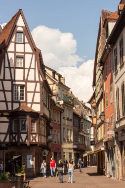 Eguisheim. Fransa. 22 Mayıs 2023. Alsace 'deki güzel Fransız köyü. Pencereli renkli ahşap bina cepheleri. Geleneksel eski mimari. Güneşli yaz günü.