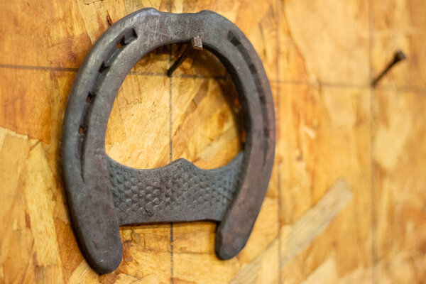 Horseshoe hang on the wall. Farm forge. Forged metal horse hoof guard