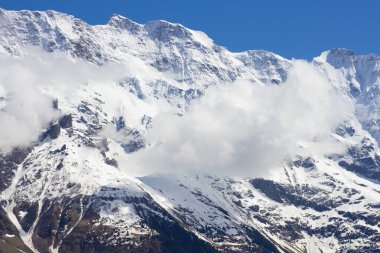 İsviçre 'deki dağlarda. Mavi gökyüzüne karşı karlı bir tepe. Turist beldesi. Avrupa 'da Doğa