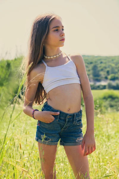 暑い夏の日に田舎の畑に立っている9歳の女の子 — ストック写真