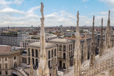 Milan, İtalya, 6 Ağustos 2023, Duomo di Milano 'yu çevreleyen binaların manzarası, kuledeki heykeller...