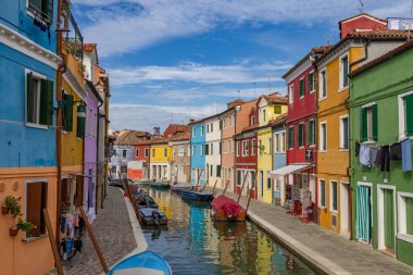 Burano, İtalya - 9 Ağustos 2023; Venedik 'teki Burano Adaları' ndaki kanal boyunca renkli Venedik evlerinin manzarası - fantastik bir seyahat noktası