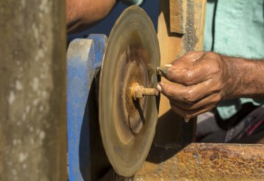 Makineyle bir parçayı keskinleştiren bir adamın eline yakın çekim. El sanatları ve geleneksel meslekler için uygundur.