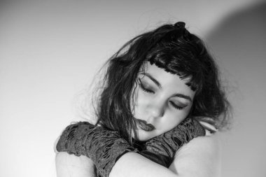 Gotik ve üzgün bakışlı bir kızın yakın portresi. Huysuz siyah beyaz fotoğraf