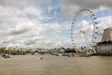 Londra, İngiltere - AUG 03, 2024 - Londra 'nın ikonik gözünün panoramik görüntüsü Thames Nehri' ne ve Londra 'nın hareketli siluetine tepeden bakan dramatik bir gökyüzüne karşı dimdik ayakta duruyor