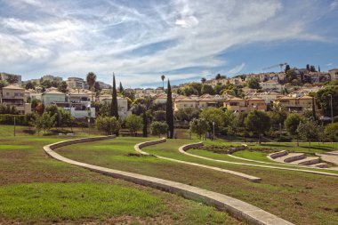 Hamoshava Park, Zichron Yaakov Israel Oct 4, 2023; Scenic Neighborhood View with Green Park and clouds in the sky clipart