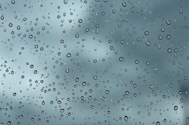 Araba camı gökyüzüne yağmur damlaları düşer