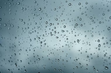 Araba camı gökyüzüne yağmur damlaları düşer
