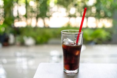 Ahşap bir masada kırmızı pipetli meşrubat.