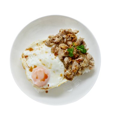 Kutsal fesleğenle kızarmış tavuk ve beyaz tabakta kızarmış yumurta.