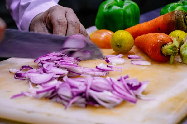 Chef Chopping Onion on a Chopping Board and preparing a meal