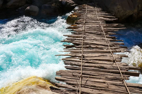 Himalayalar 'ı gezerken Darchula Nepal' de güzel mavi bir nehirde eski ahşap köprü.
