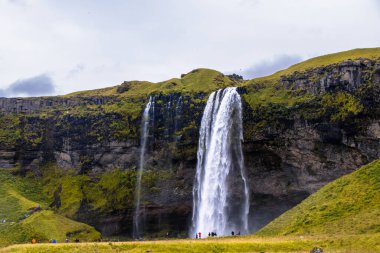 Seljalandsfoss Iceland is a stunning waterfall that allows visitors to walk behind the cascading water.