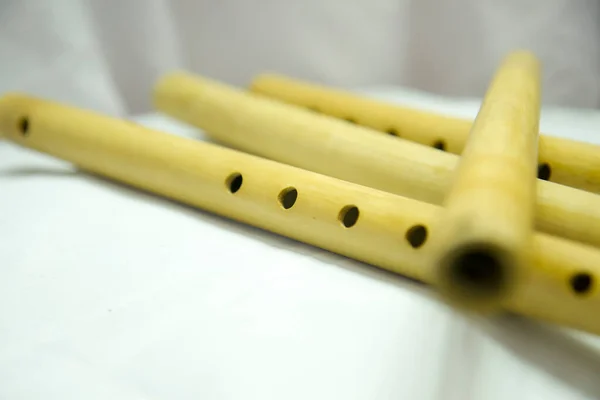 Stock image A flute with holes in it is laying on a white cloth Nepali Bamboo Flute Basuri