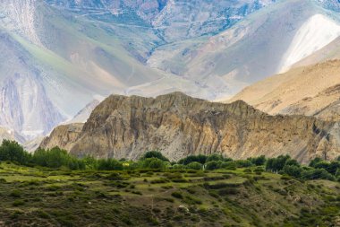 Muktinath, Mustang, Nepal 'deki Sisli Dağlar ve Uzak Evlerle Karanlık Dramatik Çöl Manzarası